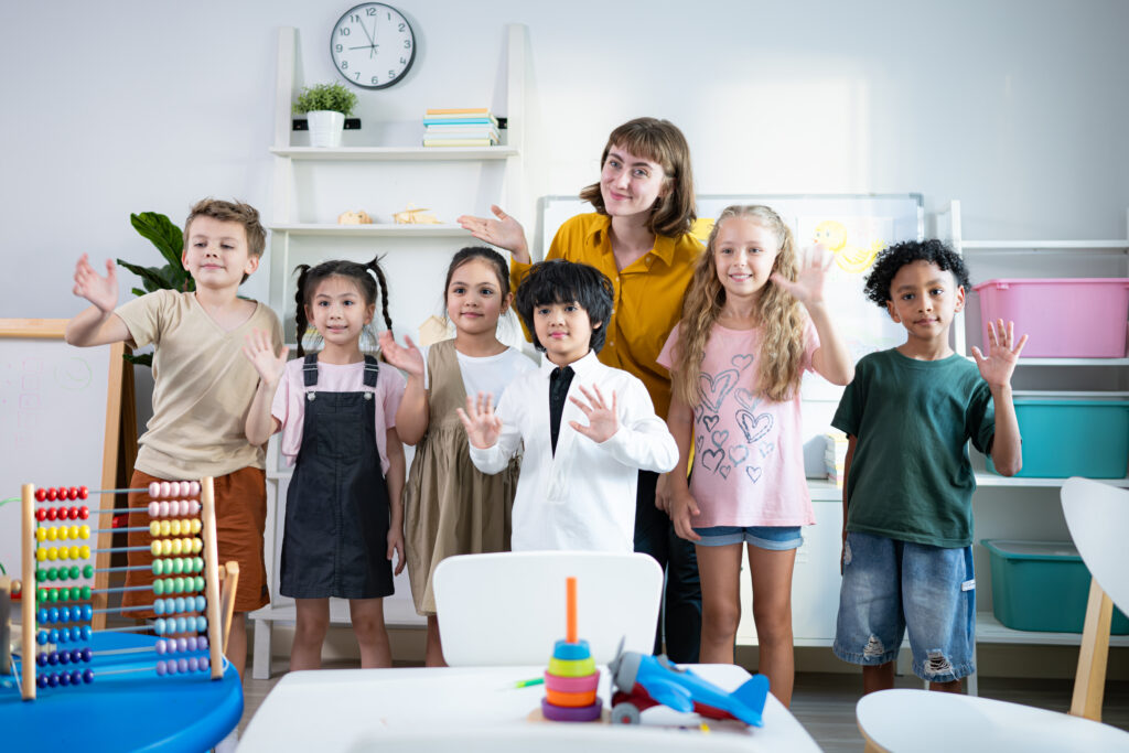Portrait of a teacher and kids in a classroom where children have pleasure learning.